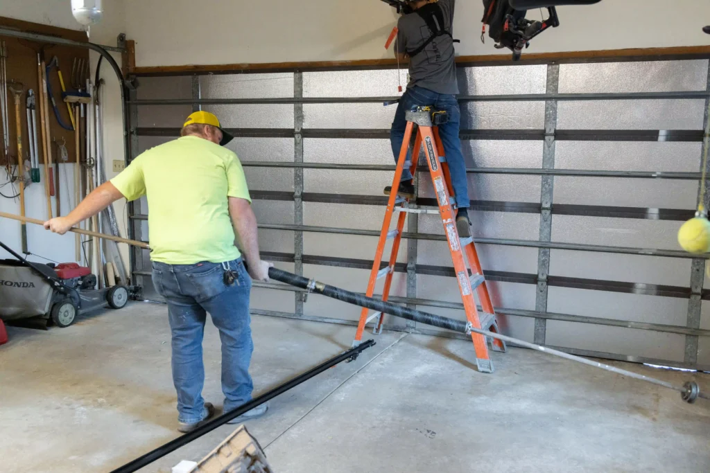 Professional garage door installers fitting a residential garage door in Centerville, Utah.